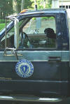 Jackie, an Explosive Detecting Canine, sits in the Explosive Technician's Vehicle, while he makes a threat assessment based on the X-rays taken of the packages.